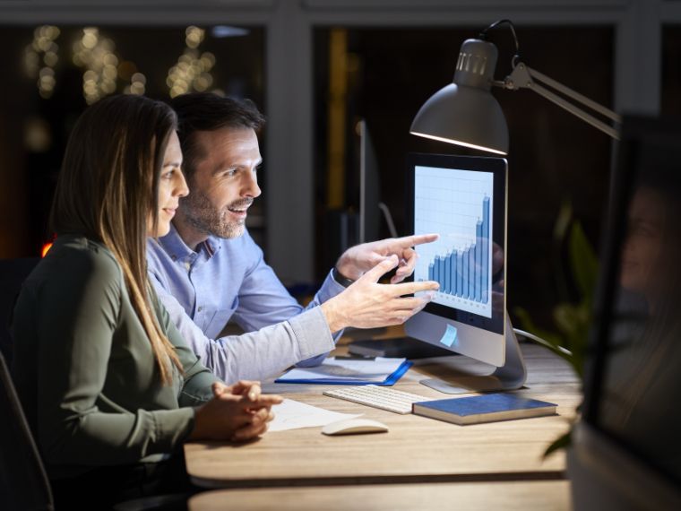 Homem e mulher trabalhando em frente a um computador. 