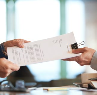 Business person giving partnership agreement to coworker